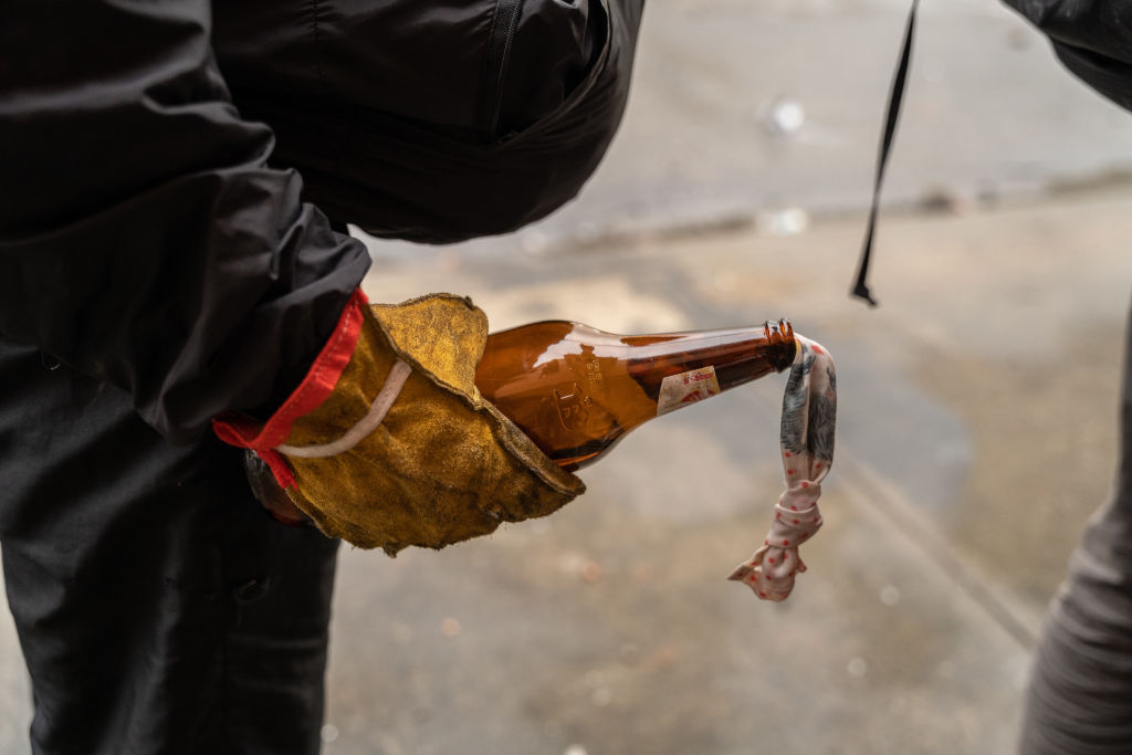 A protester holds a molotov cocktail during a protest in...