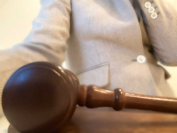 unrecognizable professional african-american woman sitting at desk behind a judge’s gavel