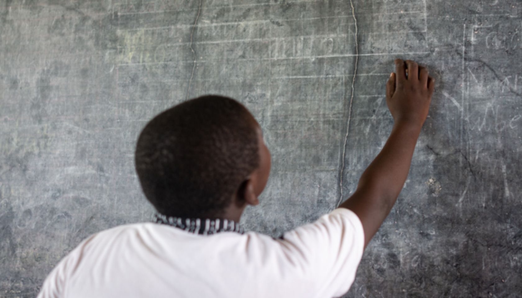 African child writing on school blackboard