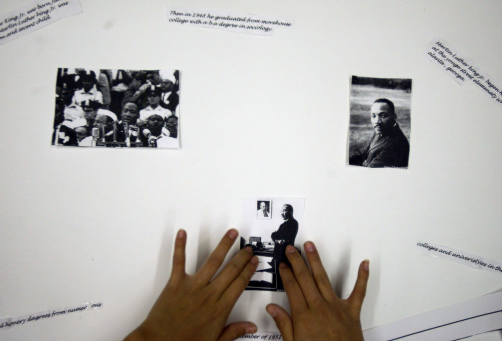 Onamia MN, 2/25/04----Vala Eagle 11, a 6th grader at Nay Ah Shing school in Onamia puts photographs of Dr. Martin Luther King on a poster for Black History month. Donna Benson is a social studies teacher at Nay Ah Shing school and the students in he