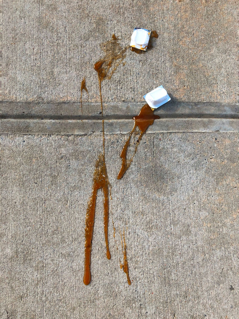 Squished packets of barbeque sauce on sidewalk, New York