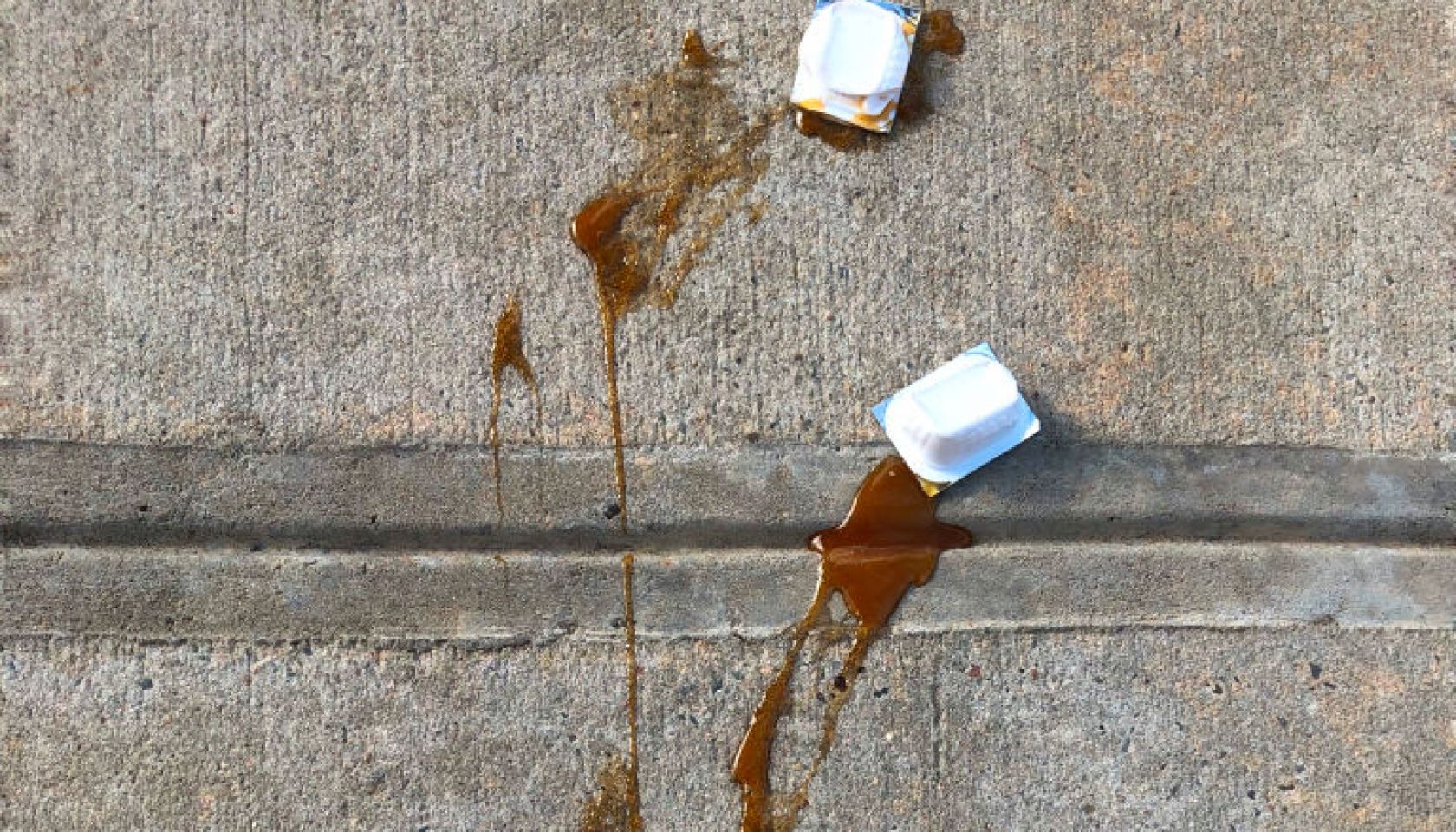 Squished packets of barbeque sauce on sidewalk, New York