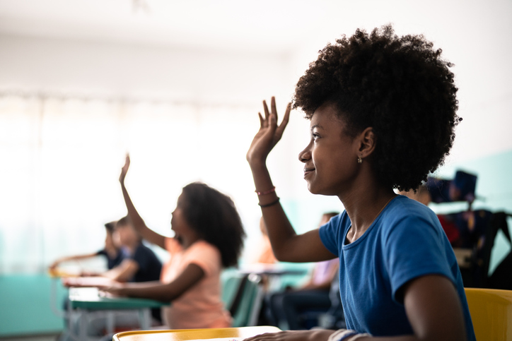 Girls with hand raised in the classroom