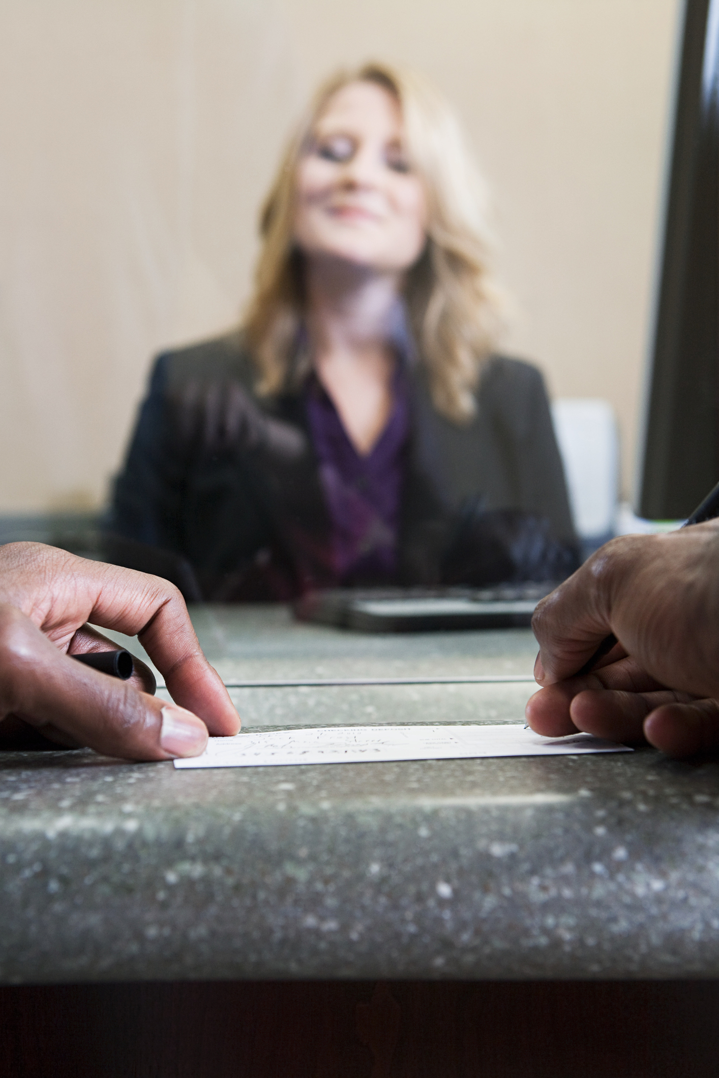 Customer writing cheque in bank