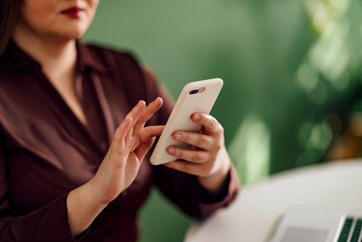 An Anonymous Businesswoman Typing on her Mobile Phone