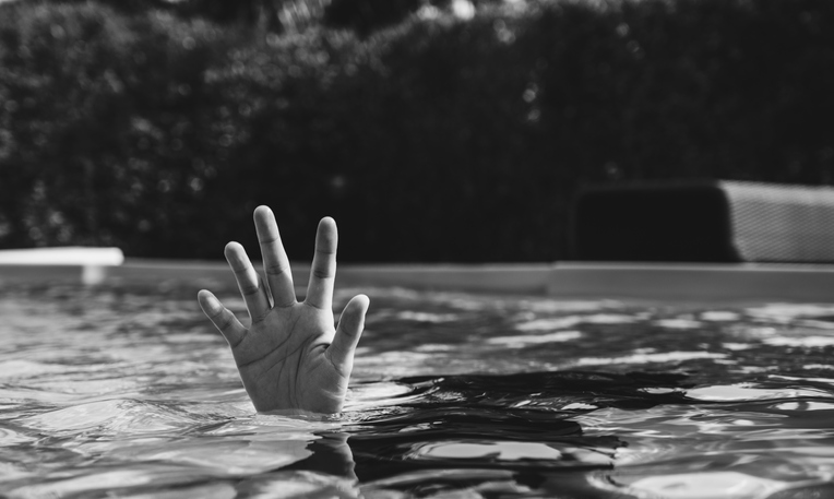 Hand of person drowing in swimming pool. Black and White tone.