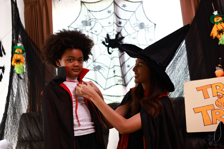 Beautiful woman with black witch costume dress Vampire Ghost to her son for Halloween party , Asian beautiful woman or mother and little boy dressing up Halloween costume