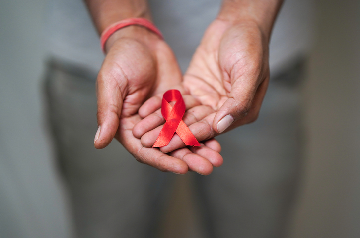 Worlds HIV Aids Day, Men Holding A red ribbon In his hand, HIV Aids Awareness, Close up shot of Men Holding Red ribbon in white background HIV AIDS concept, Health Concept