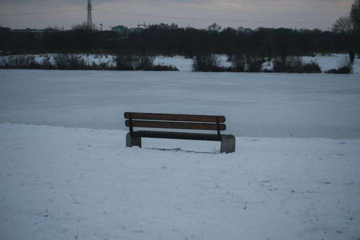 A lonely bench on the bank of the frozen lake