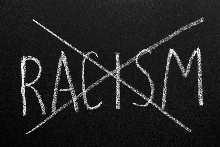 Crossed out word Racism written with chalk on blackboard