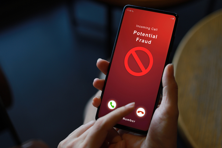 Person receiving a potential fraud call on smartphone from an unknown caller, copy space.