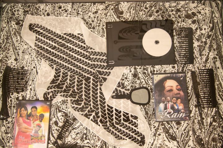 Nontsikelelo Mutiti, 'EVERYTHING IS WHERE IT IS EXPECTED,' 2019 , screen printed satin scarf, marbled paper, selection of Nollywood DVD's and hair dressing objects. Installation view of exhibition at Printed Matter, New York.