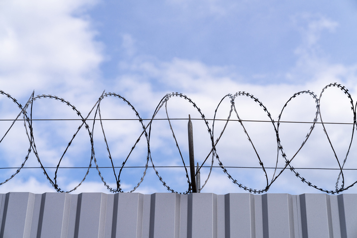 Security dangerous barricade. Barbed wire and razor wire crossing.
