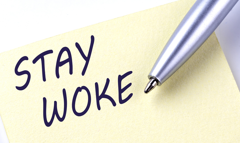 Sticky Note Message STAY WOKE with pen on white background
