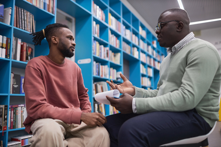 African American male therapist talking to student in mental health session