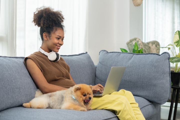 Young women working in the living room with her dog