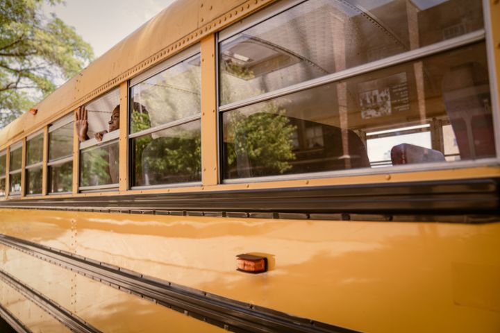 Junior-high Black students arrive to school via school bus.