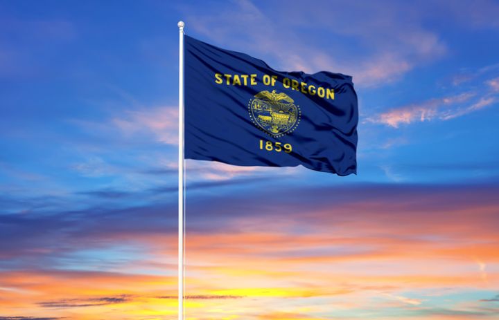 flag of Oregon on flagpoles and blue sky. Patriotic concept about state.