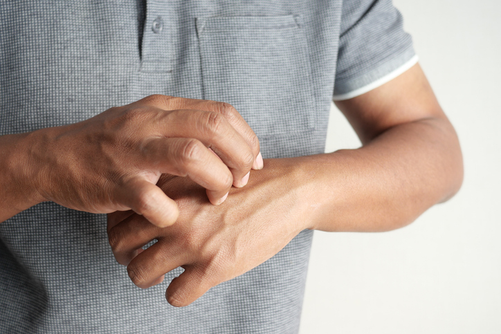 man suffering from itching skin, close up.