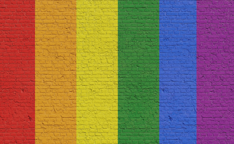 LGBTQ community colors painted on a brick wall.