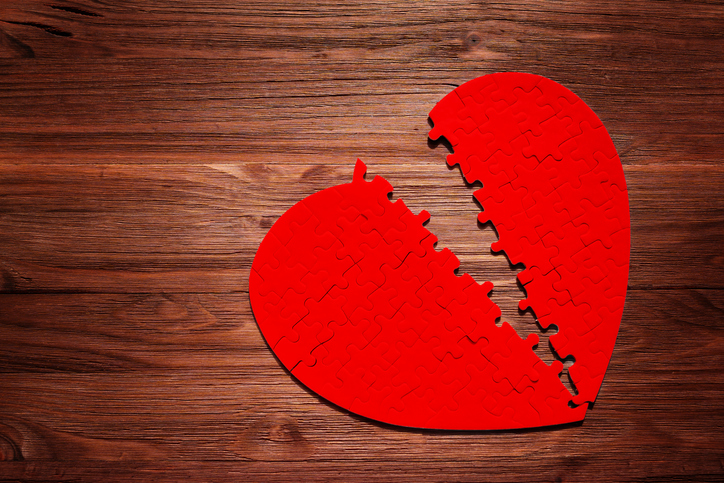 Red Heart Puzzle Split in Half on a Wooden Table