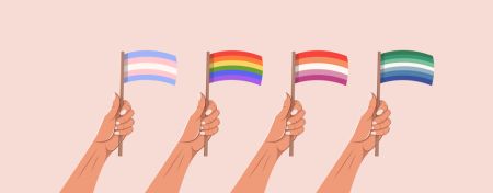 Set of hands holding pride LGBTQ flags.