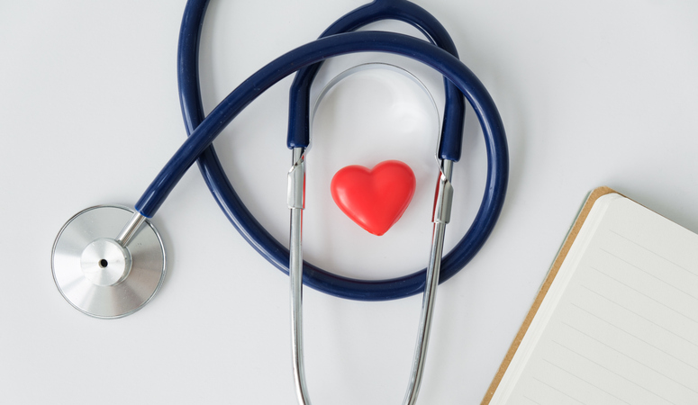 The concept of family insurance and medical care. a stethoscope and a heart figurine