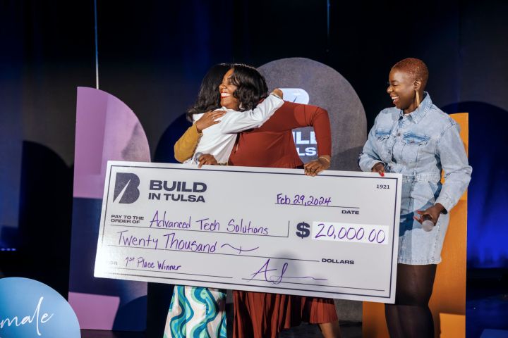 Ashli Sims presenting the first place winner of Female Founders Pitch Night with a check for $20,000