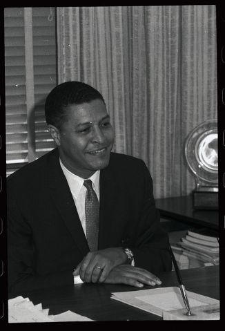 Clifton R. Wharton Sitting at his Desk