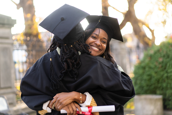 Two female graduates hugging in celebration