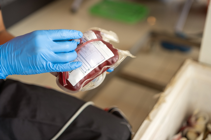 Close-up of a blood bag filled with fresh donor blood at the Red Cross office, emphasizing donation, medical care, and life-saving healthcare services.