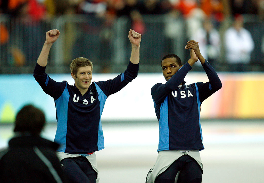 Gold medalist United States Shani Davis, from Chicago, Ill., right, claps his hands as his teammate