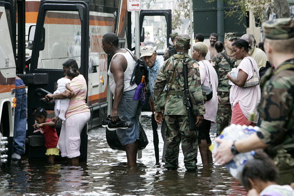 Soldiers watch people boarding buses nea
