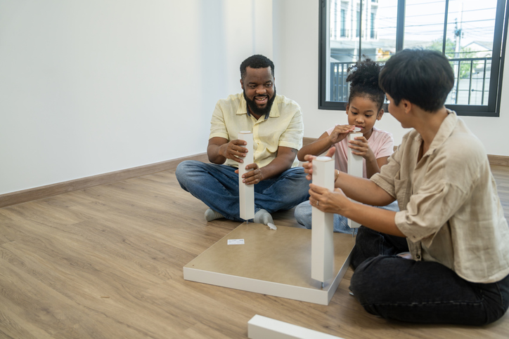 Family assembling furniture together in new home
