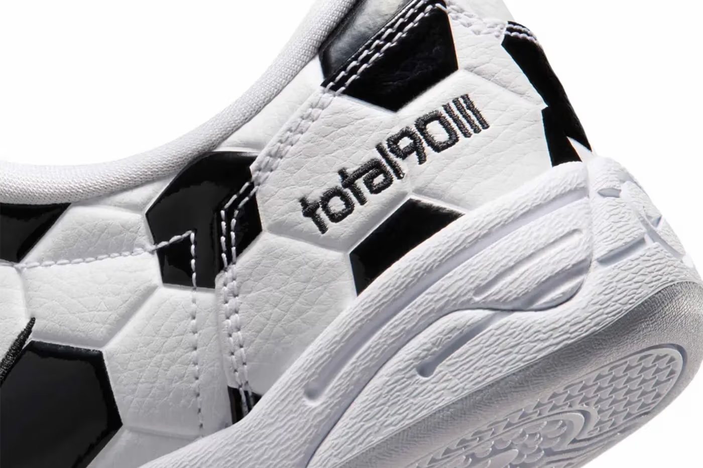 Close-up of a white and black athletic shoe with the Adidas logo visible.