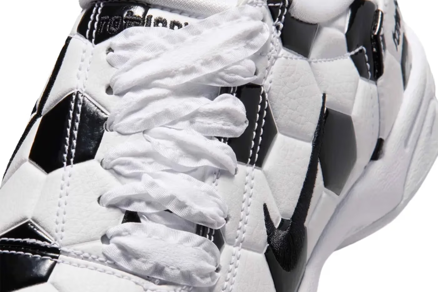 Close-up of a pair of white and black athletic shoes with laces tied.