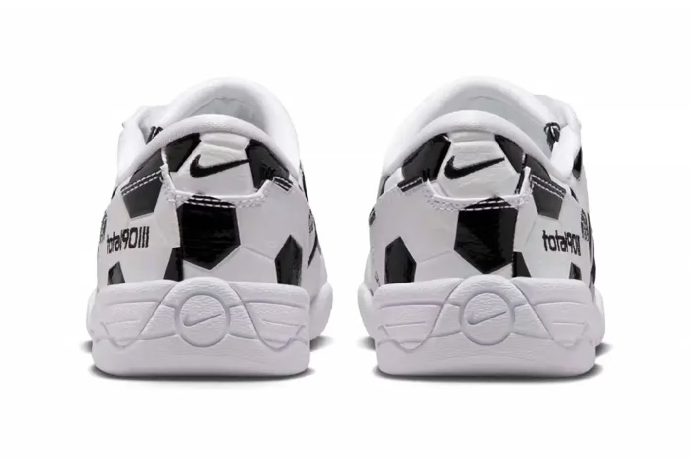 A pair of white and black Nike sneakers with a soccer ball pattern printed on them.