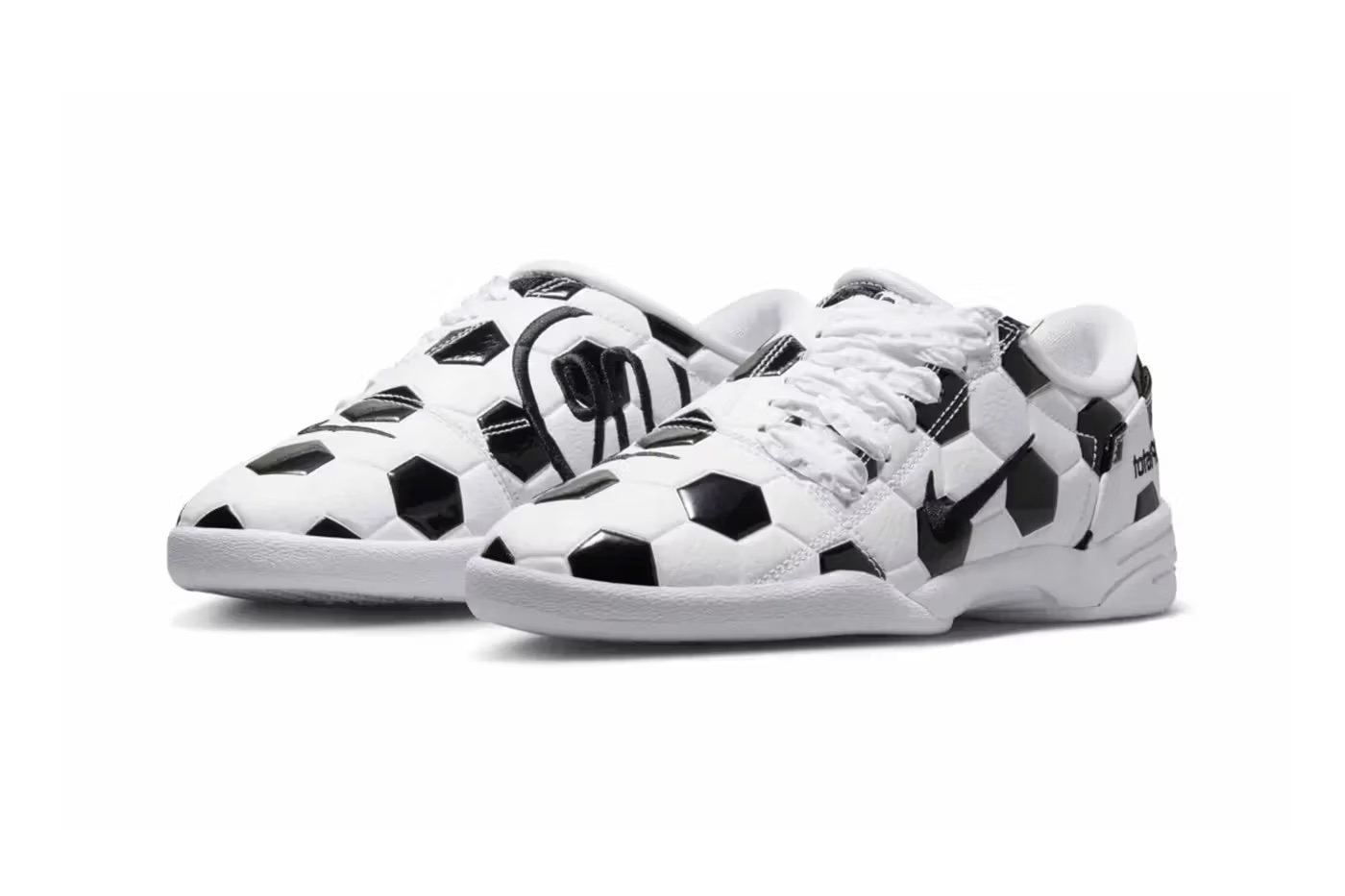 A pair of white sneakers with a black and white geometric pattern resembling soccer balls.