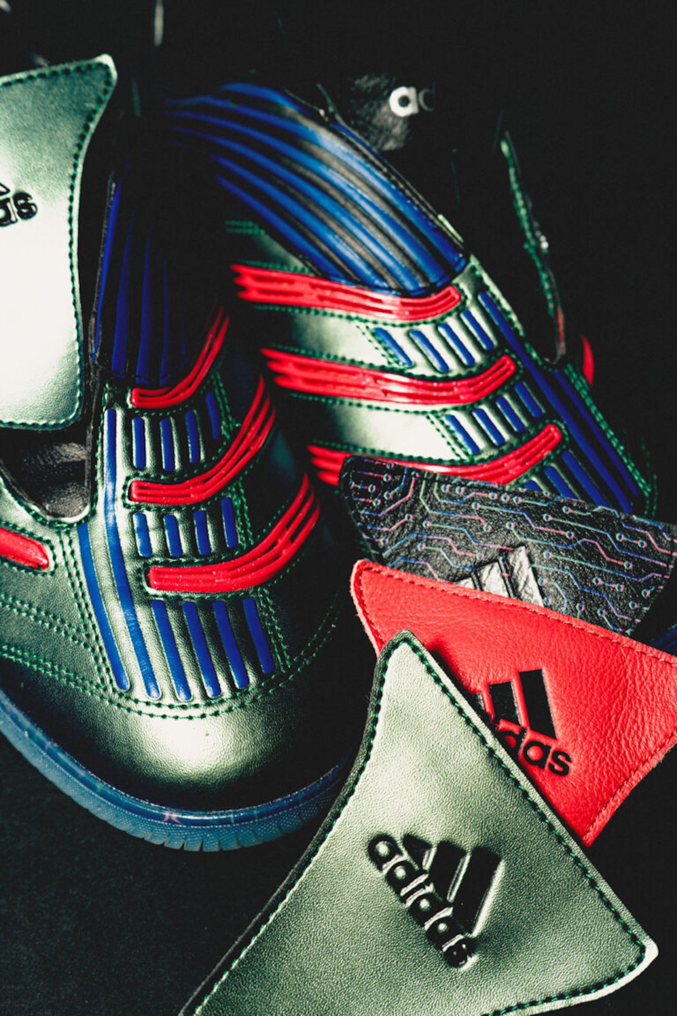 Closeup of a colorful Adidas athletic shoe with red, blue, and green stripes and accents.