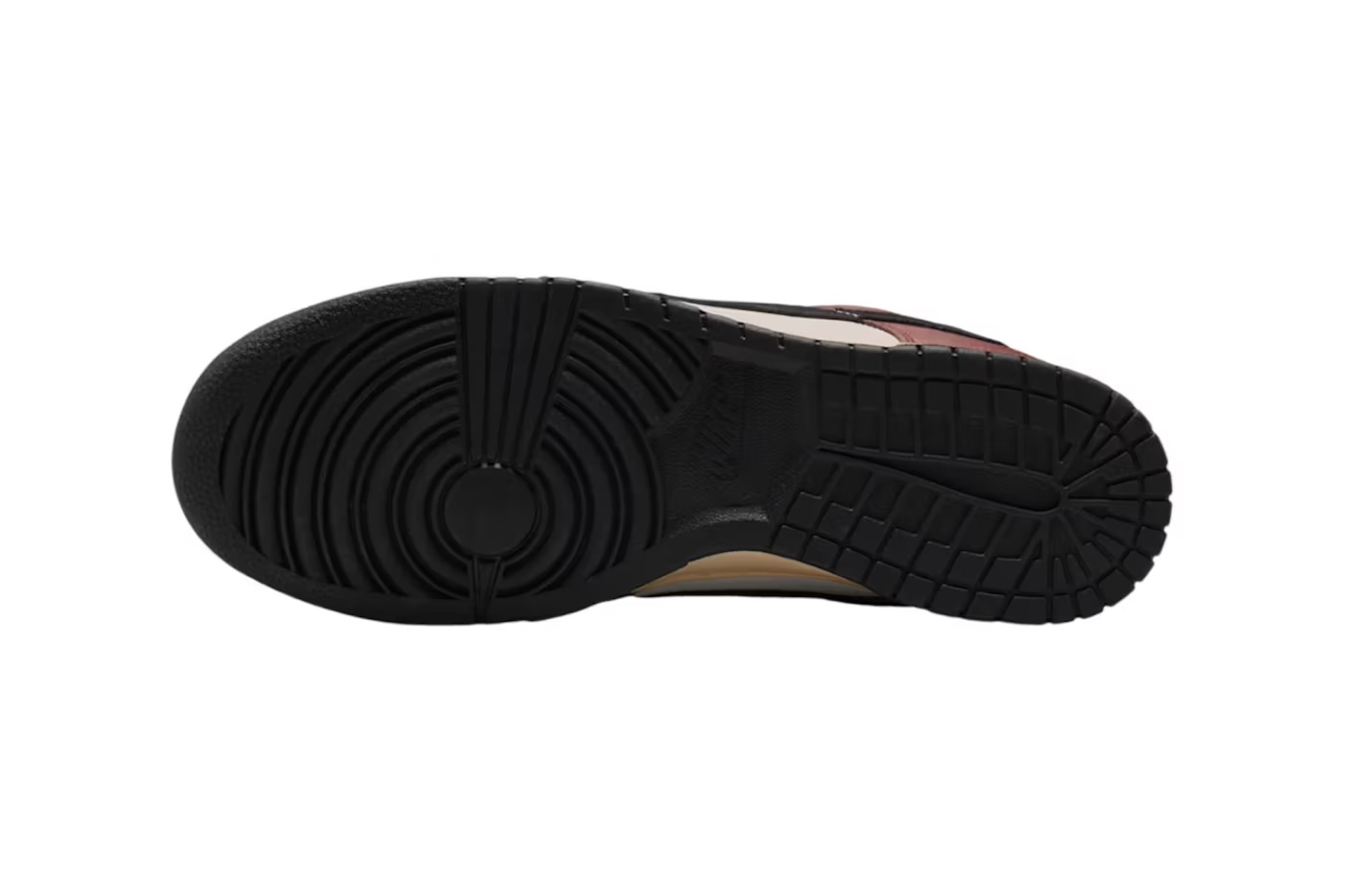 A close-up view of a black and brown sneaker sole with a textured, grooved pattern.