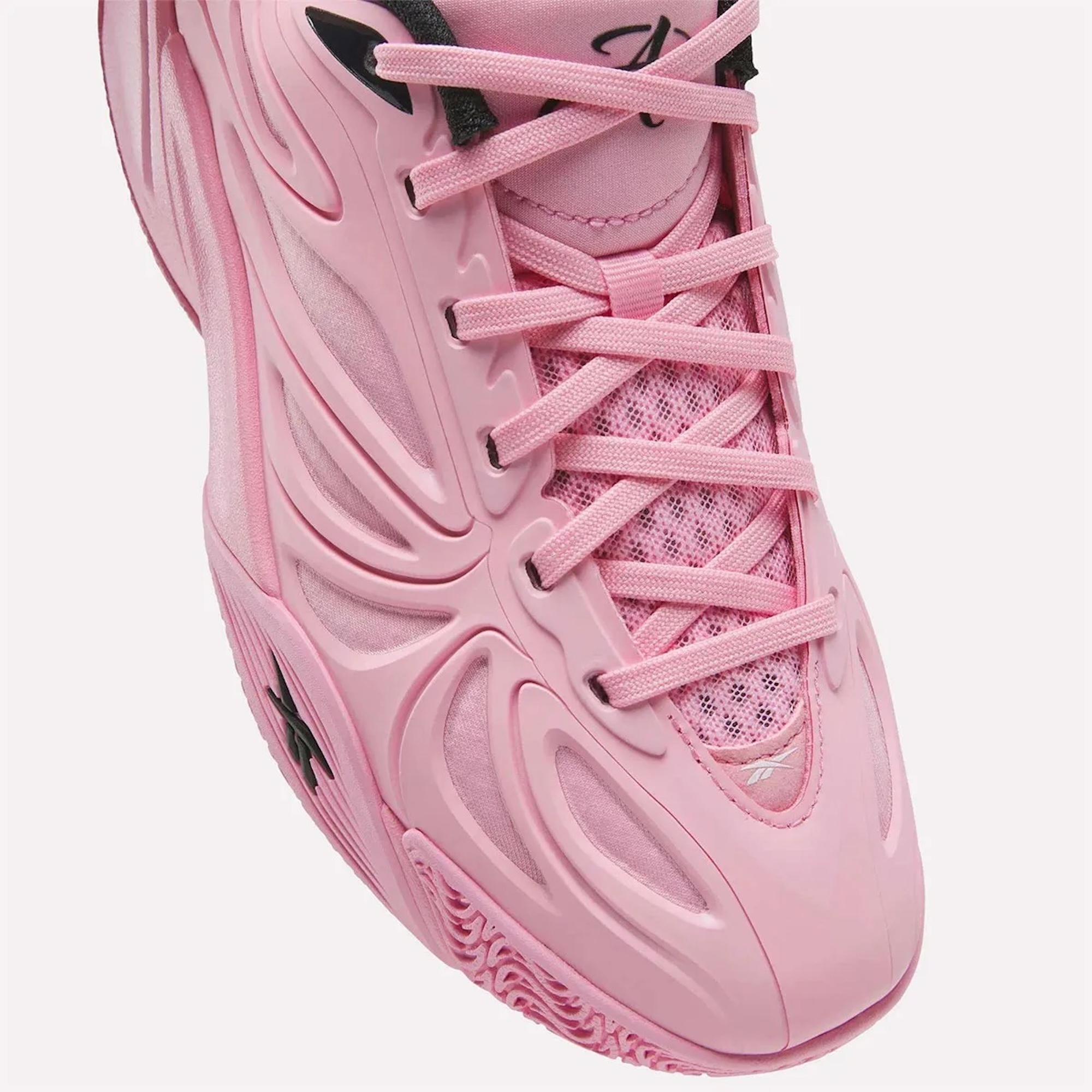 Close-up of a pink athletic shoe with intricate lacing and textured design.