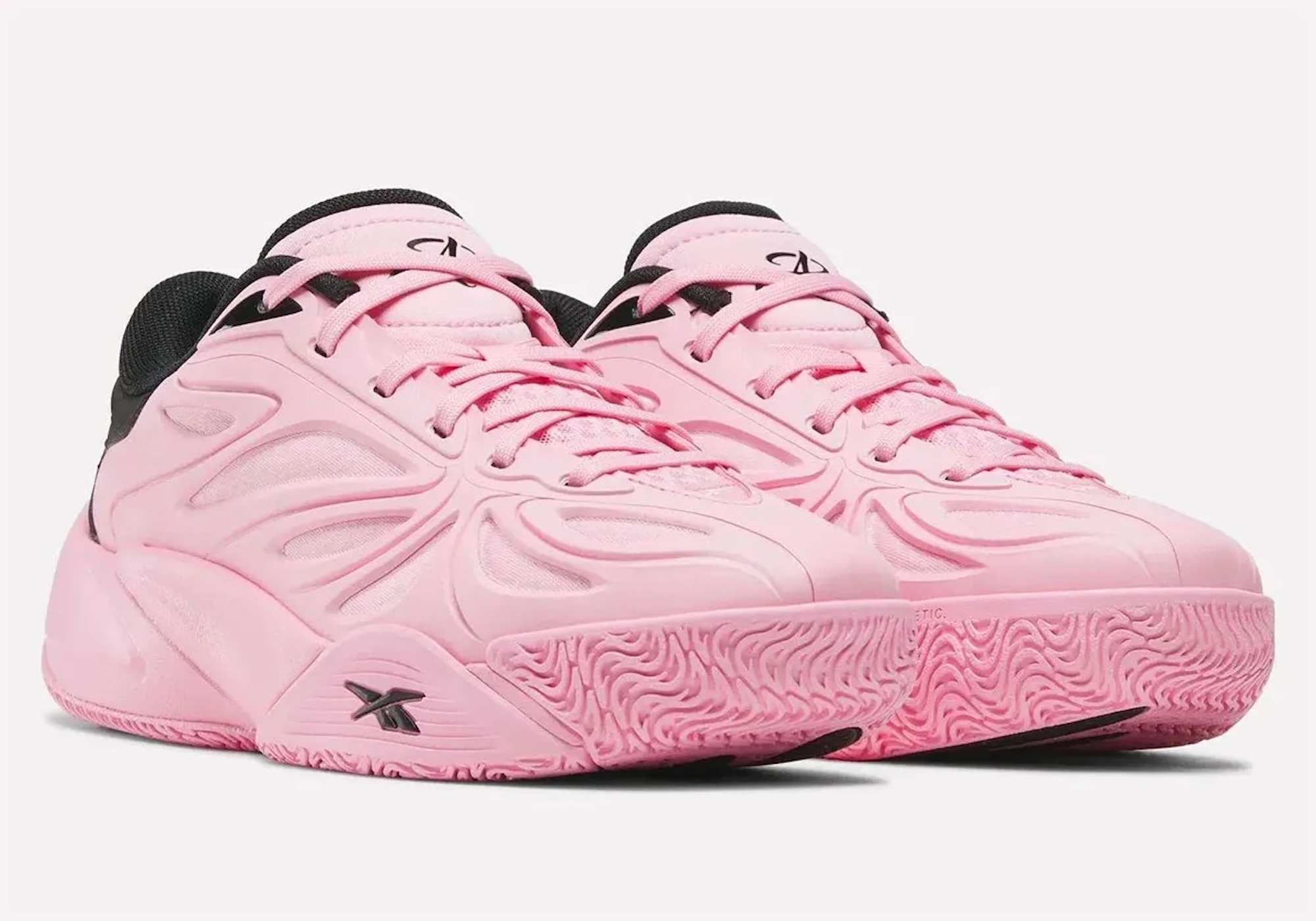 A pair of pink sneakers with a distinctive wavy pattern and black accents.