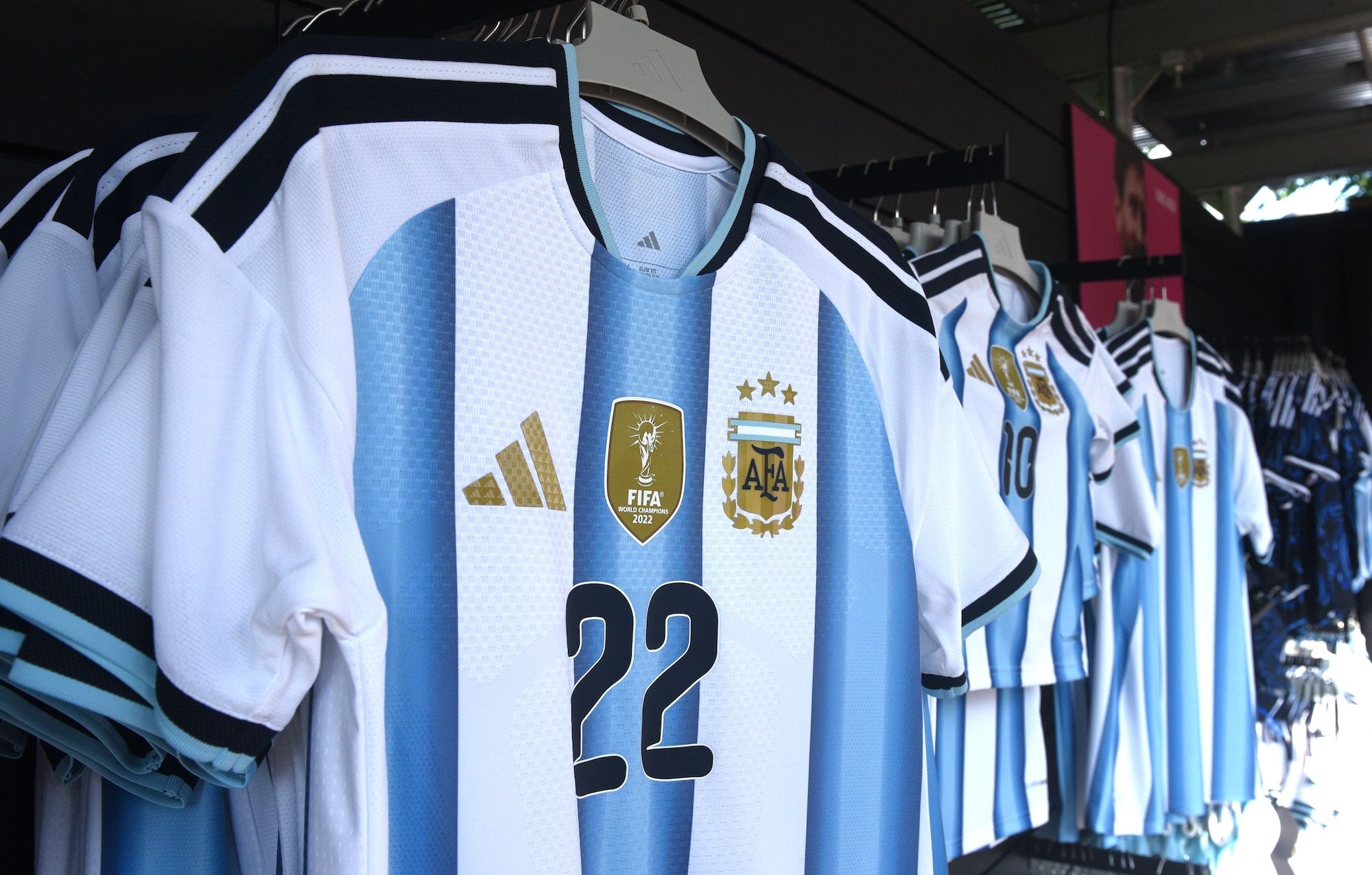 Rows of white and blue soccer jerseys with Adidas, FIFA, and Argentina national team logos and player number 22.