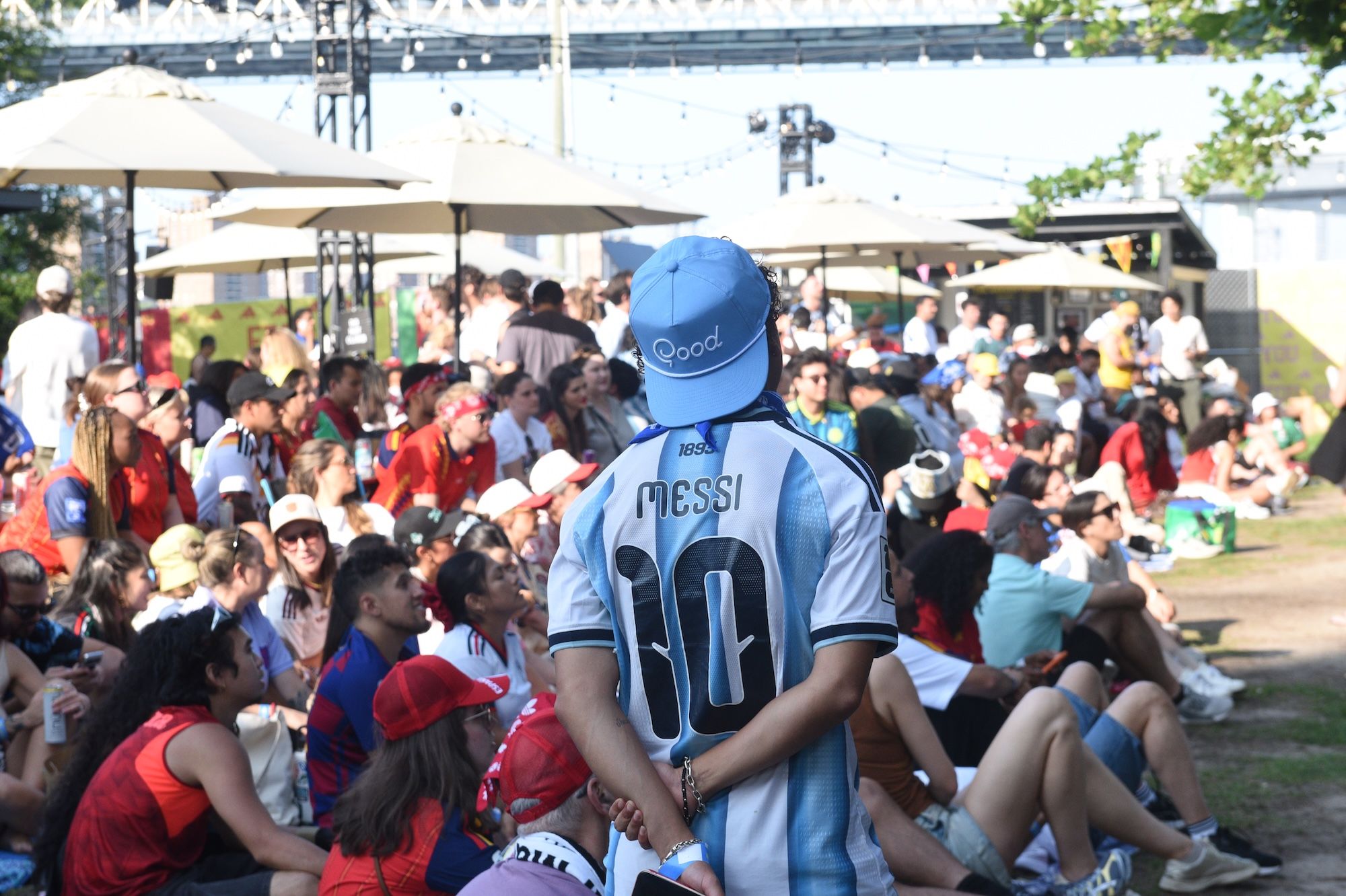 Crowd of people in a park setting, with a person wearing a jersey with the name "Messi" and the number 10.
