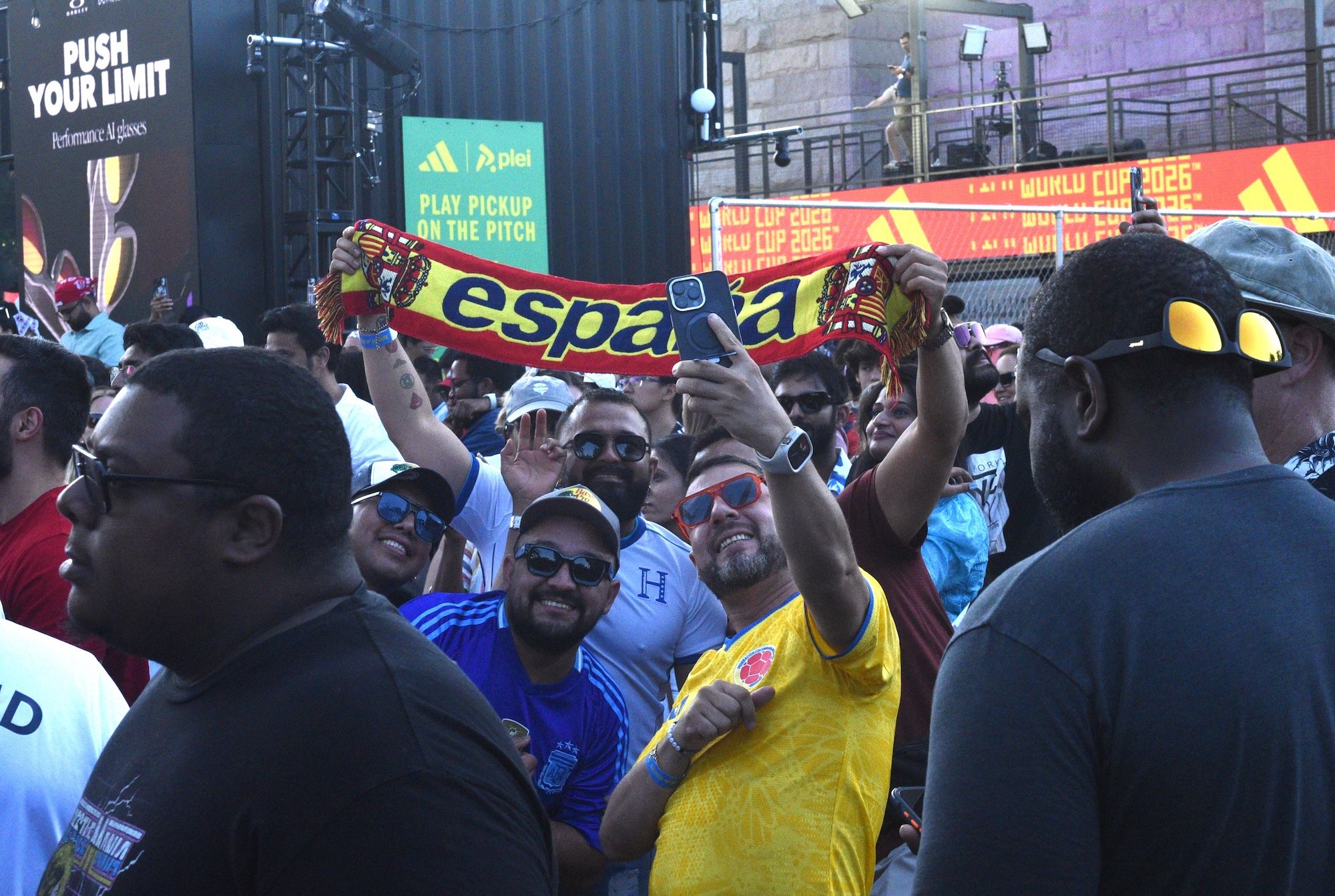 Crowd of people holding up a large "Espana" flag at a sports event or celebration.