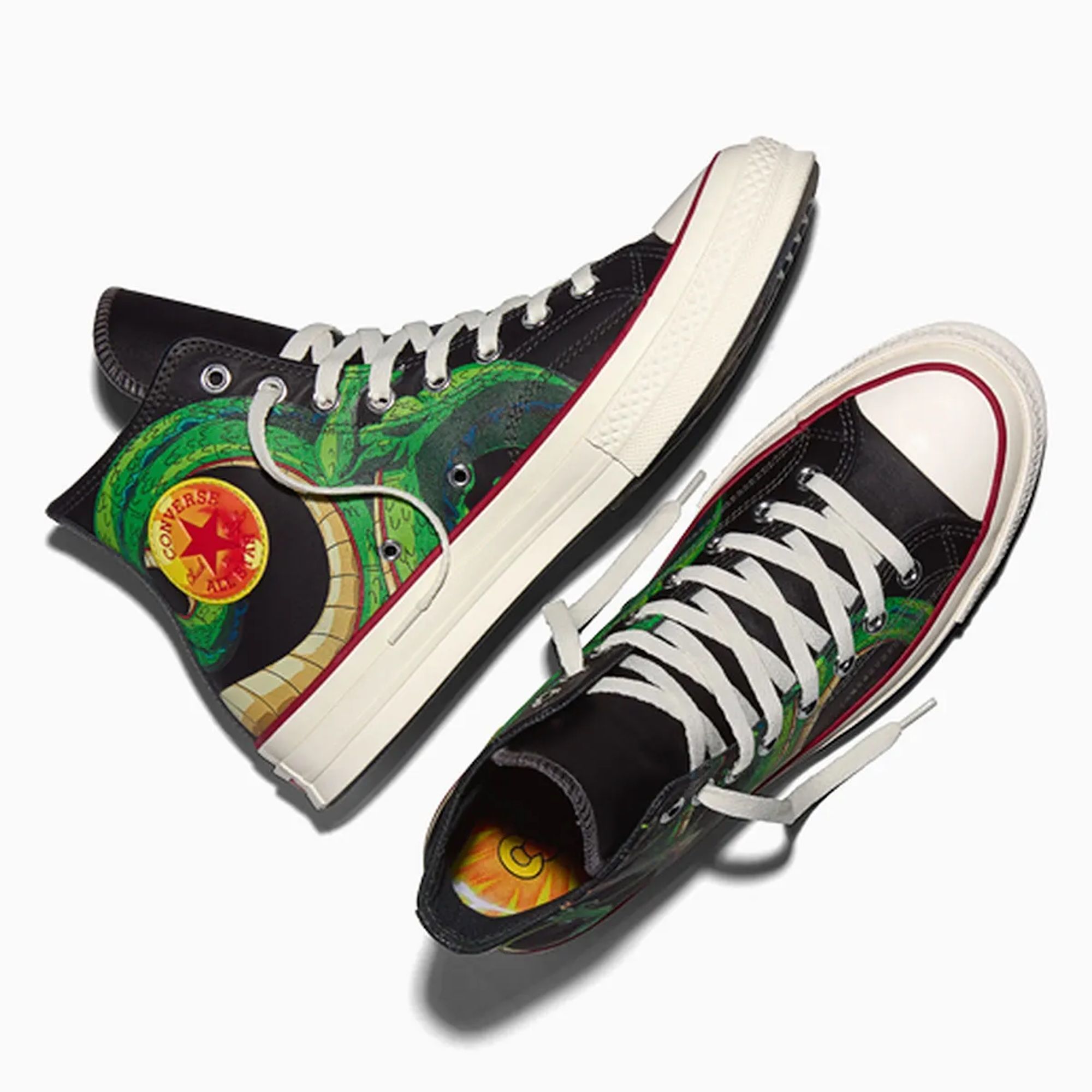 Pair of black and green high-top sneakers featuring a Converse All Star logo and colorful graphic design.
