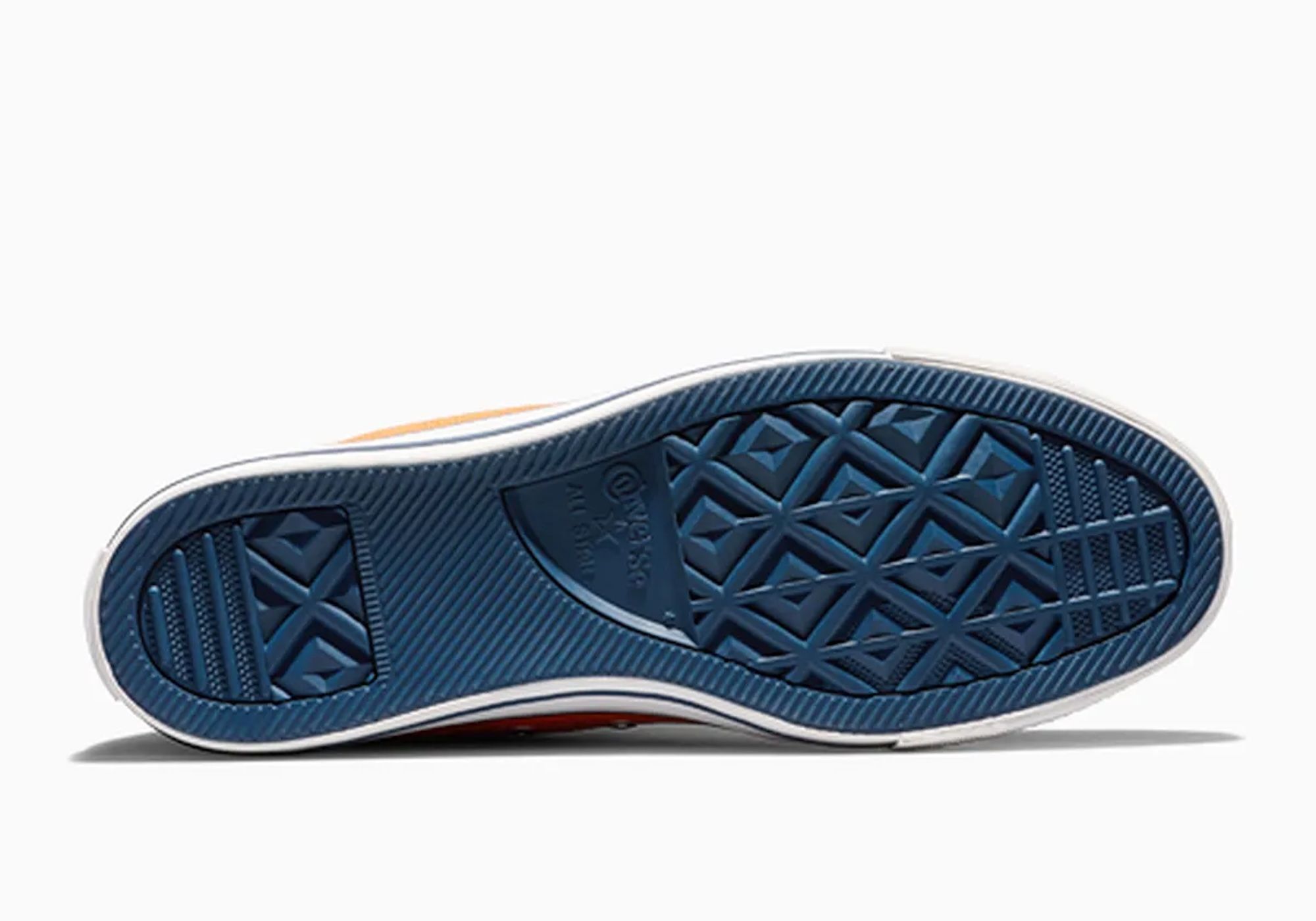 Close-up of a navy blue and orange sneaker sole with a textured tread pattern.