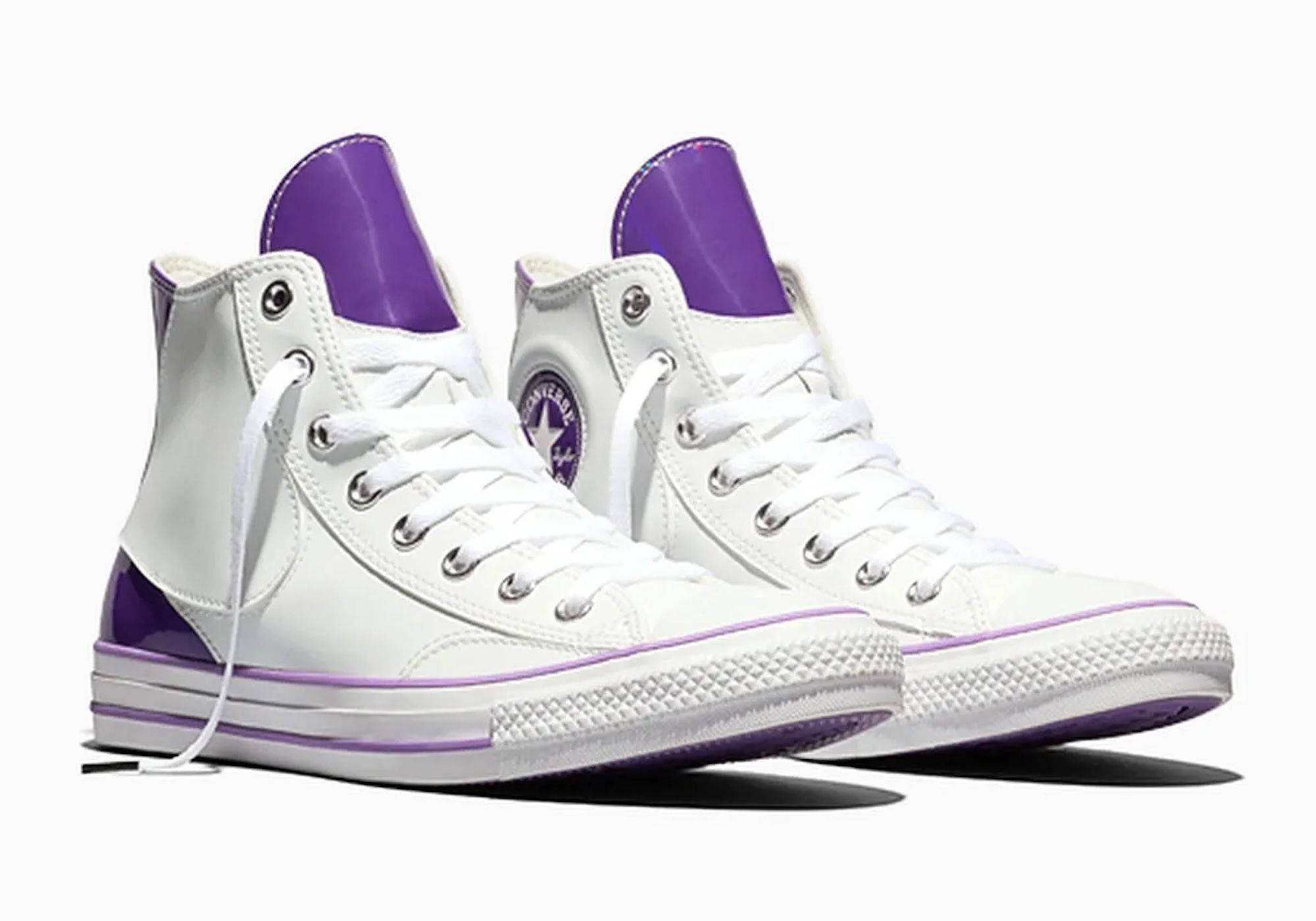 A pair of white high-top Converse sneakers with purple accents.