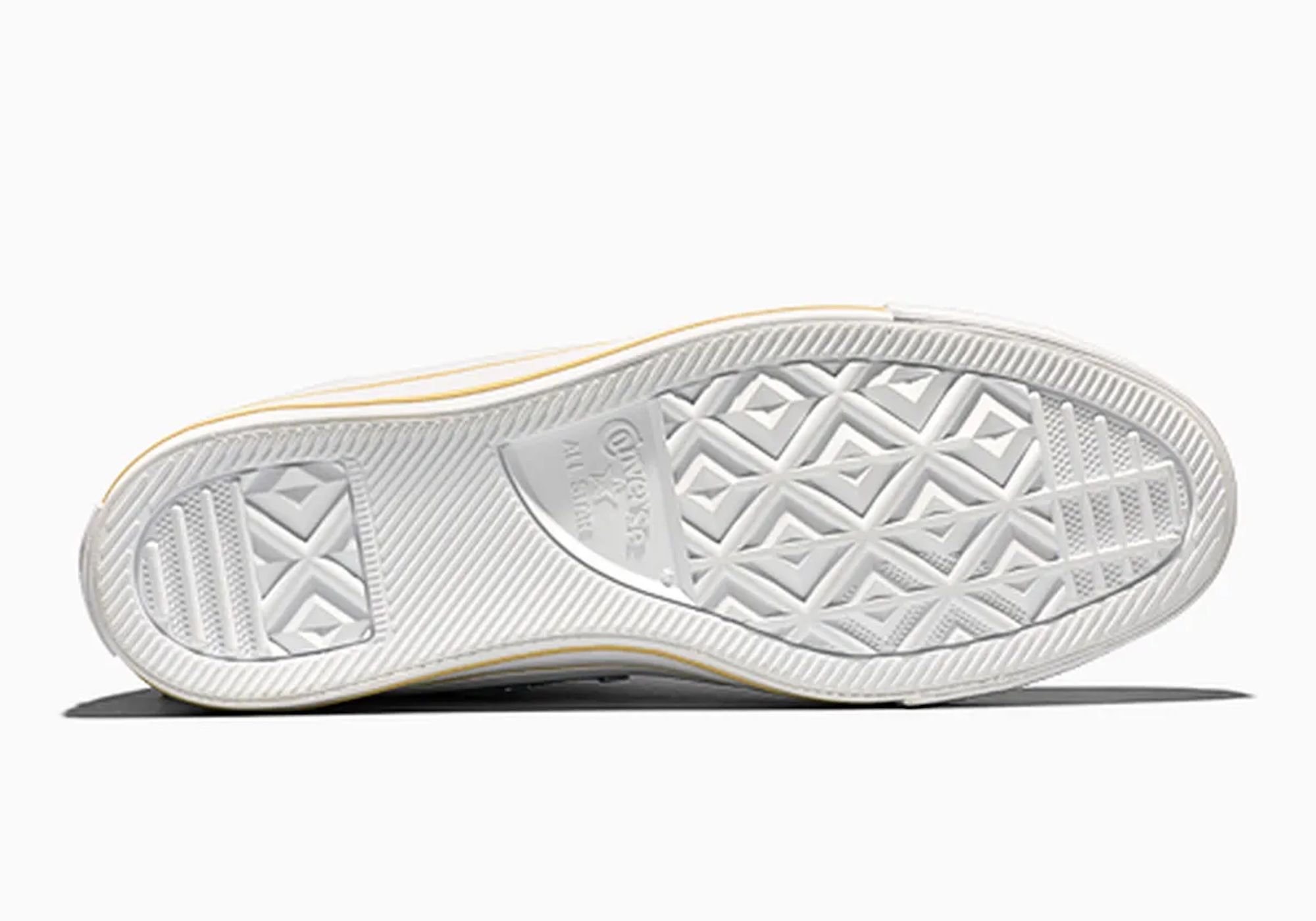 A close-up view of the sole of a sneaker, featuring a textured, diamond-patterned tread design.