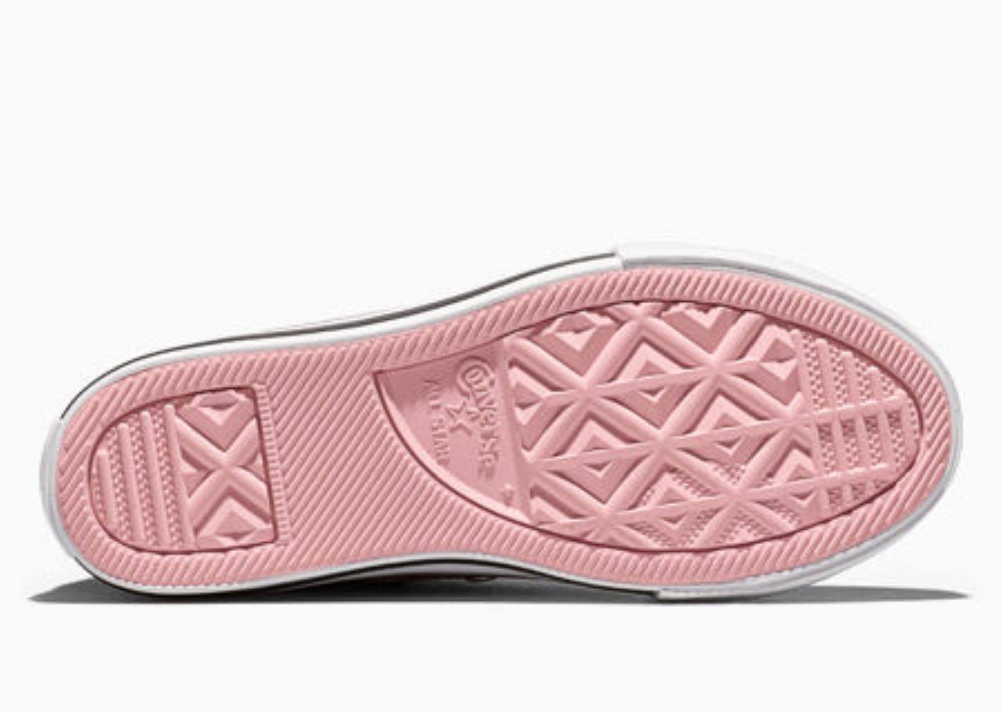 Close-up of a pink and white sneaker sole with a diamond pattern tread.